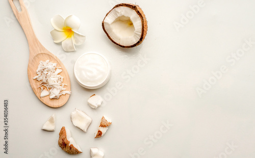 Homemade coconut products on white wooden table background. Oil, scrub, milk, lotion, mint and himalayan salt from top view. Good for space and background