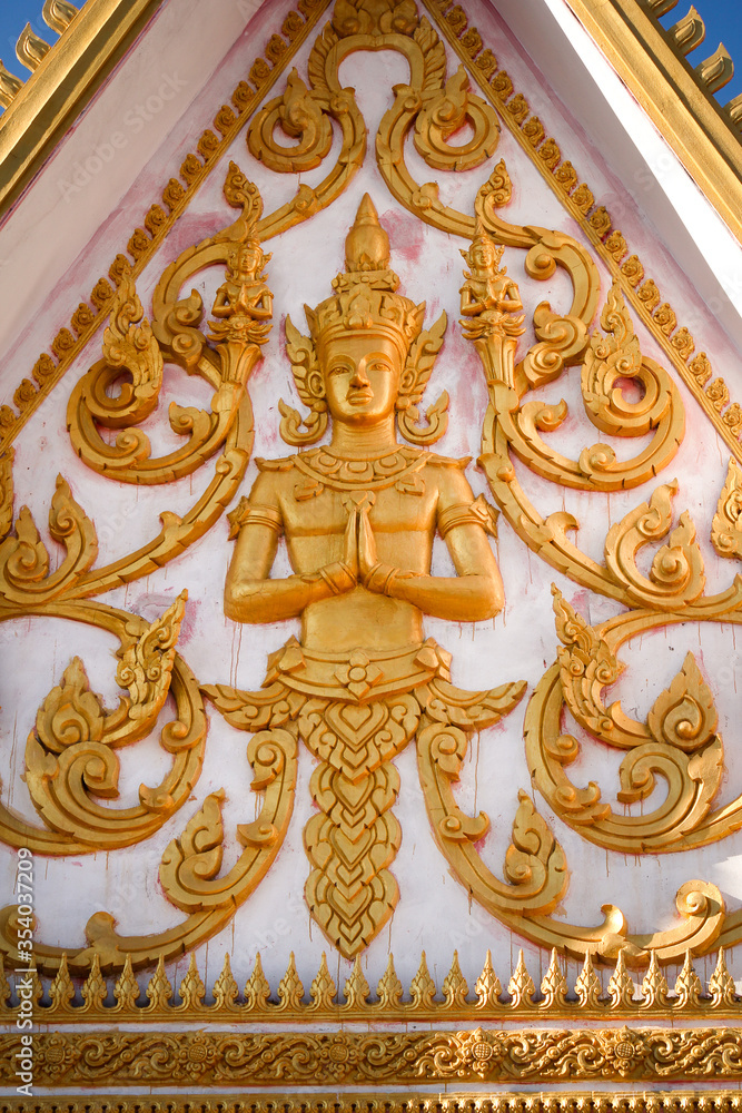Golden fresco of a buddha image in a wat or buddhist temple site in Siamese Lao PDR, Southeast Asia