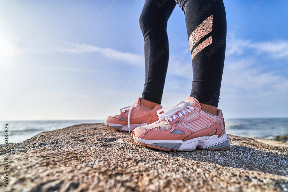 Sporty athletic fitness woman wearing pink comfortable sport shoes for running outdoors