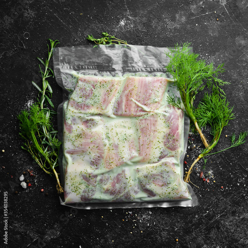 Vacuum packaging with raw marinated ribs in a creamy sauce. Top view. Free space for your text. photo