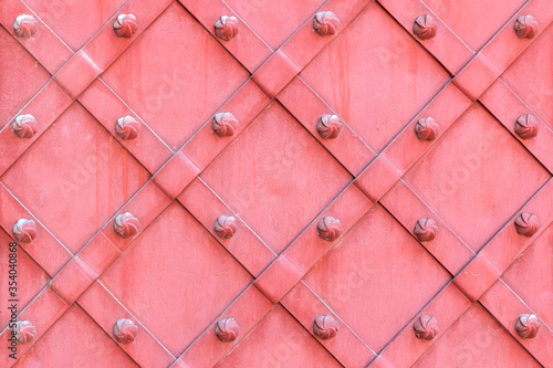 Pink surface of wrought iron doors. Vintage metallic texture background.