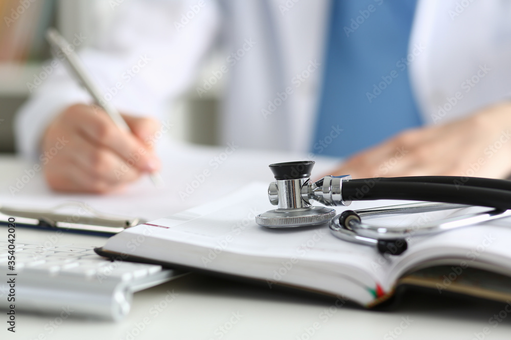 Fototapeta premium Stethoscope head lying on medical forms closeup