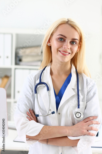 Beautiful smiling female doctor stand in office portrait