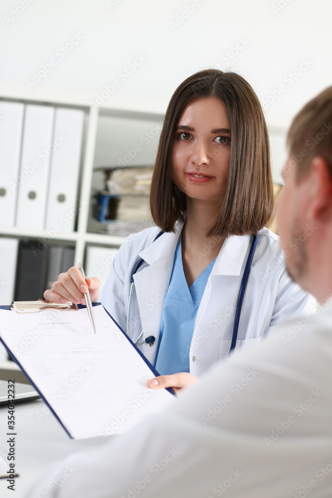 Female doctor hand hold silver pen and showing pad Female doctor hand hold silver pen and showing pad