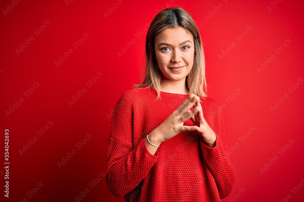 Young beautiful blonde woman wearing casual sweater over red isolated background Hands together and fingers crossed smiling relaxed and cheerful. Success and optimistic Young beautiful blonde woman wearing casual sweater over red isolated background Hands together and fingers crossed smiling relaxed and cheerful. Success and optimistic