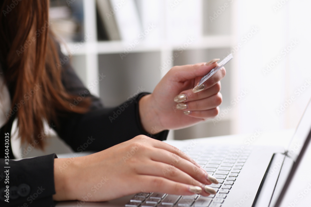 Business woman in the office holds a plastic credit debit card in her hand Business woman in the office holds a plastic credit debit card in her hand