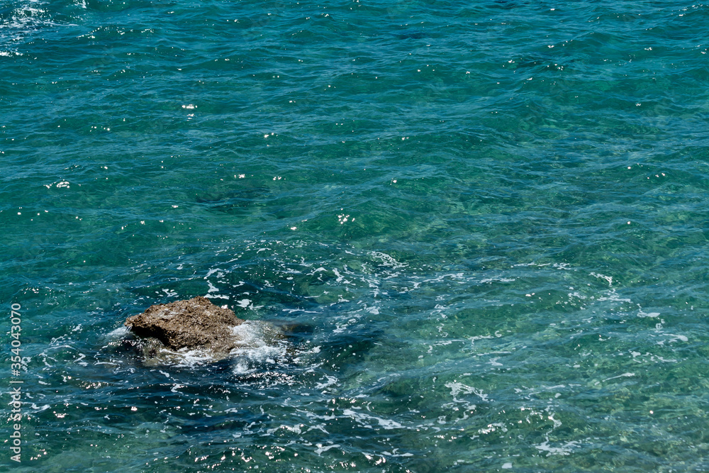 Obraz premium Texture of rippled sea water with rock