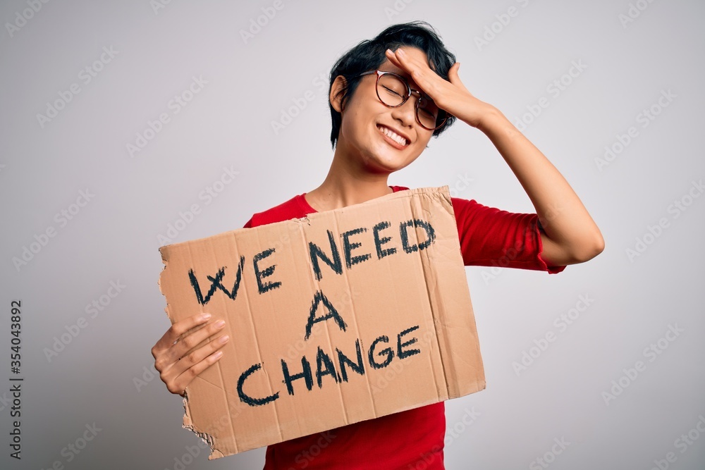 Beautiful asian girl protesting holding banner with change message over white background stressed with hand on head, shocked with shame and surprise face, angry and frustrated. Fear and upset Beautiful asian girl protesting holding banner with change message over white background stressed with hand on head, shocked with shame and surprise face, angry and frustrated. Fear and upset