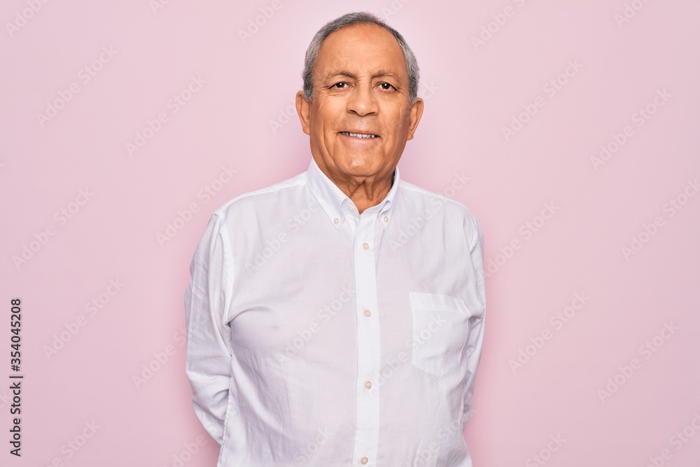 Senior handsome grey-haired man wearing elegant shirt over isolated pink background with a happy and cool smile on face. Lucky person. Senior handsome grey-haired man wearing elegant shirt over isolated pink background with a happy and cool smile on face. Lucky person.