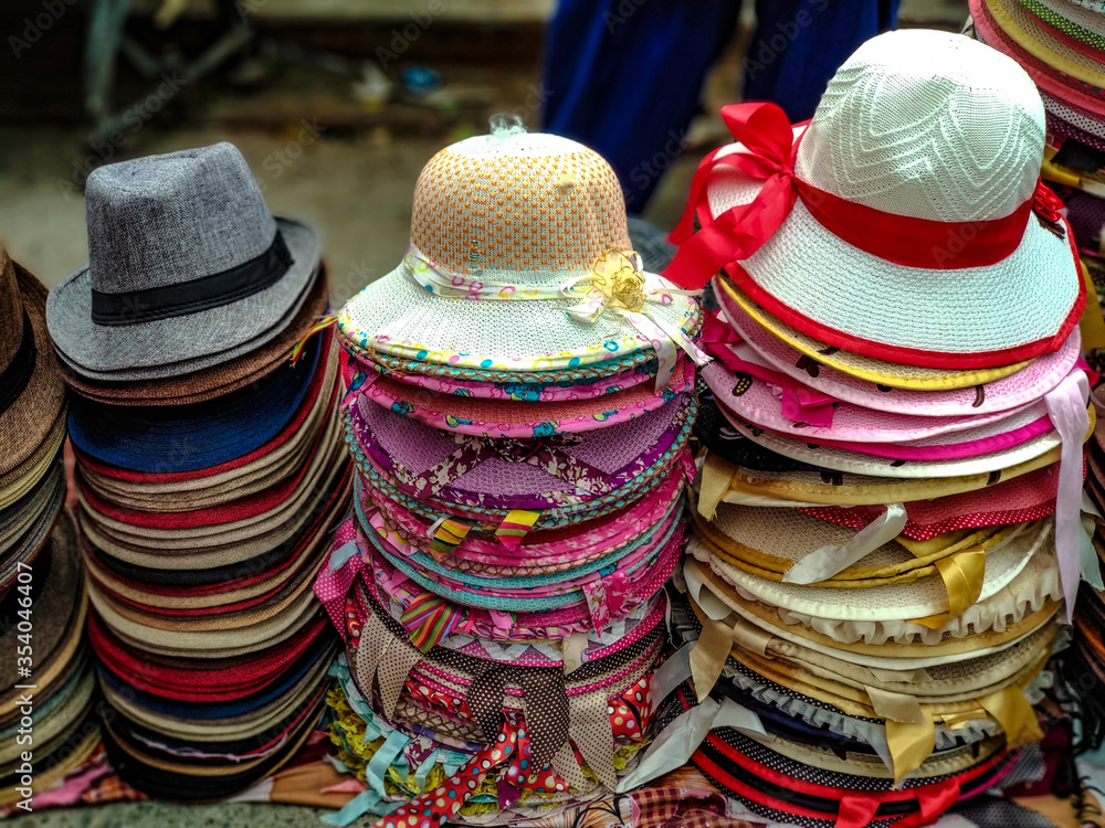 Colorful designer Hats and caps stacked on one another. They are kept on display for sale. These street market cheap souvenirs are popular among tourist 