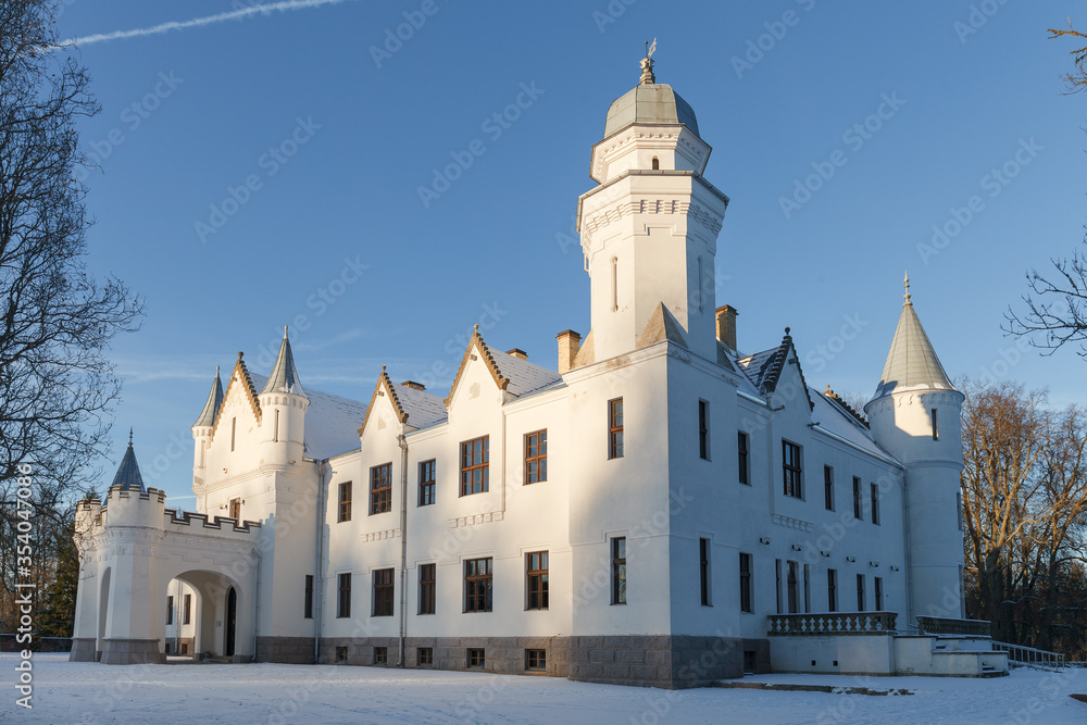 Neo gothic Alatskivi castle at winter. White building and white snow around.