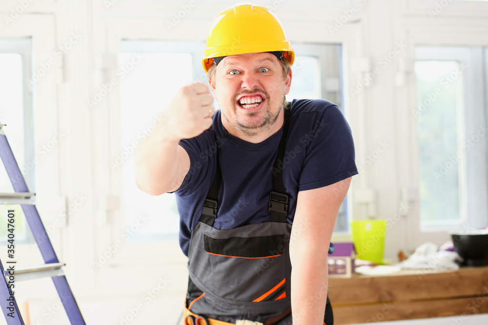 Smiling funny worker in yellow helmet posing Smiling funny worker in yellow helmet posing