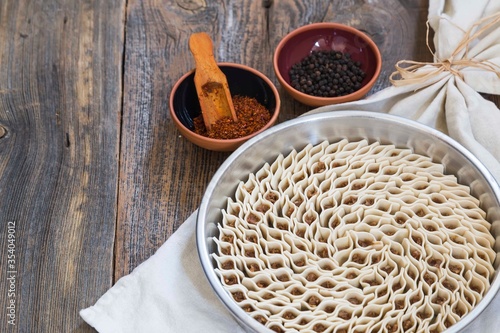 
traditional kayseri tray ravioli with pepper on wooden background. turkish food .