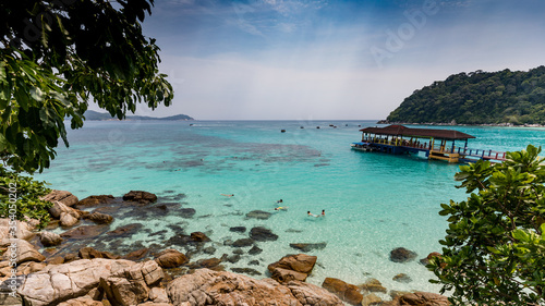 Snorkelling people in turquoise water on tropical Malaysian island Perhentian Besar