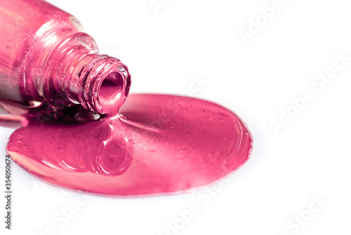 pink nail polish spilled on a white table photo