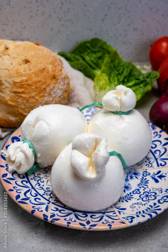 Cheese collection, fresh soft Italian cheese from Puglia, white balls of burrata or burratina cheese made from mozzarella and cream filling