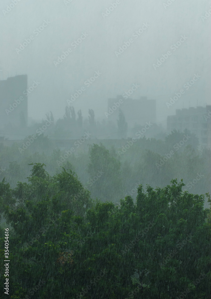 Shower in a residential area on the background of trees and buildings. Shower in a residential area on the background of trees and buildings.