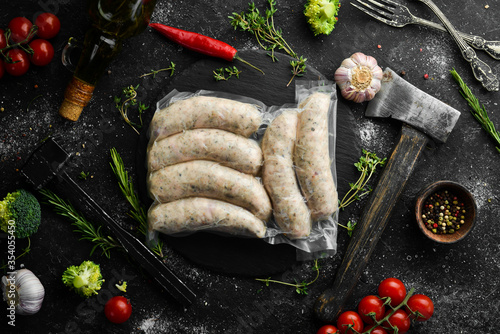 Raw sausages from turkey meat in vacuum packing. Top view. On a black background.