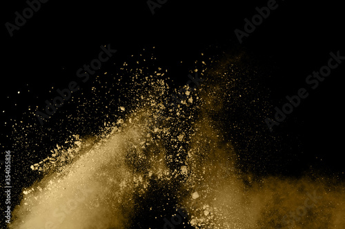 Złoty prochowy wybuch na czarnym tle. Zatrzymaj ruch.