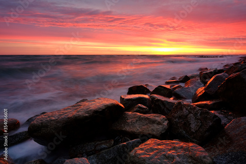 Morze Bałtyckie,wschód słońca,sztormowe fale oblewają kamienisty brzeg,Kołobrzeg,Polska.
