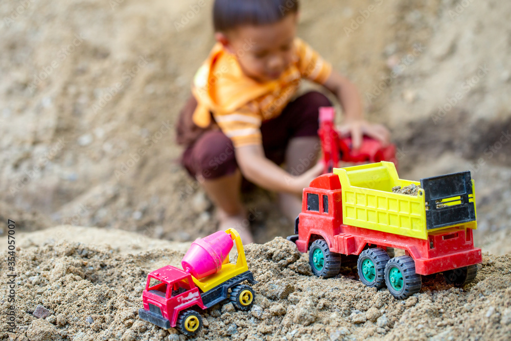 The boy is playing his toy on the pile of soil. At his home to be safe from an epidemic The boy is playing his toy on the pile of soil. At his home to be safe from an epidemic