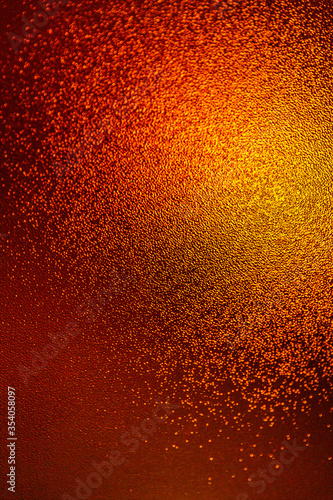 Closeup view of sparkling orange glitter background. metallic shimmer texture of material, glimmering wall background
