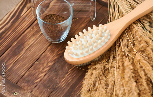 Brush, washcloth for body massage and skin cleaning with natural coffee scrub on beige background. Spa.
