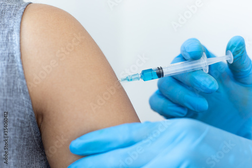 Vaccination of patients, Doctor provided a vaccine with a syringe against a new strain of virus or influenza in a modern hospital, Prevention and health care concept.