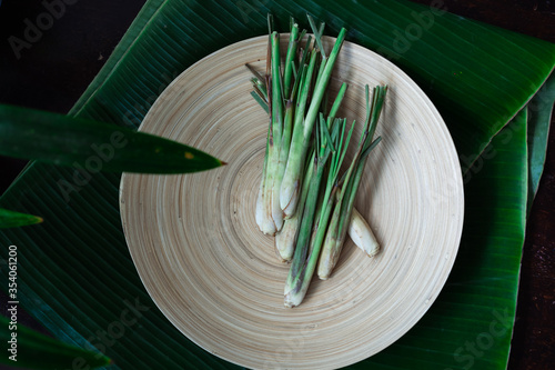 Fresh Lemongrass (Cymbopogon citratus) or citronella, serai on a wooden plate.