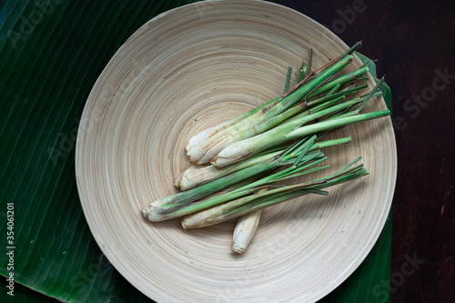 Fresh Lemongrass (Cymbopogon citratus) or citronella, serai on a wooden plate.