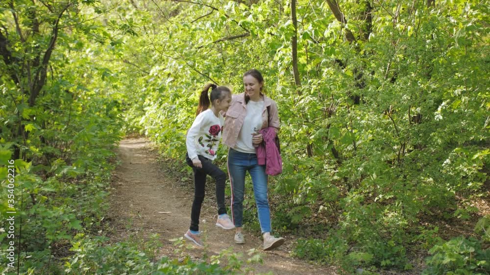 Woman with little daughter walking in spring Park. Family walks in the fresh air. Woman with little daughter walking in spring Park. Family walks in the fresh air.