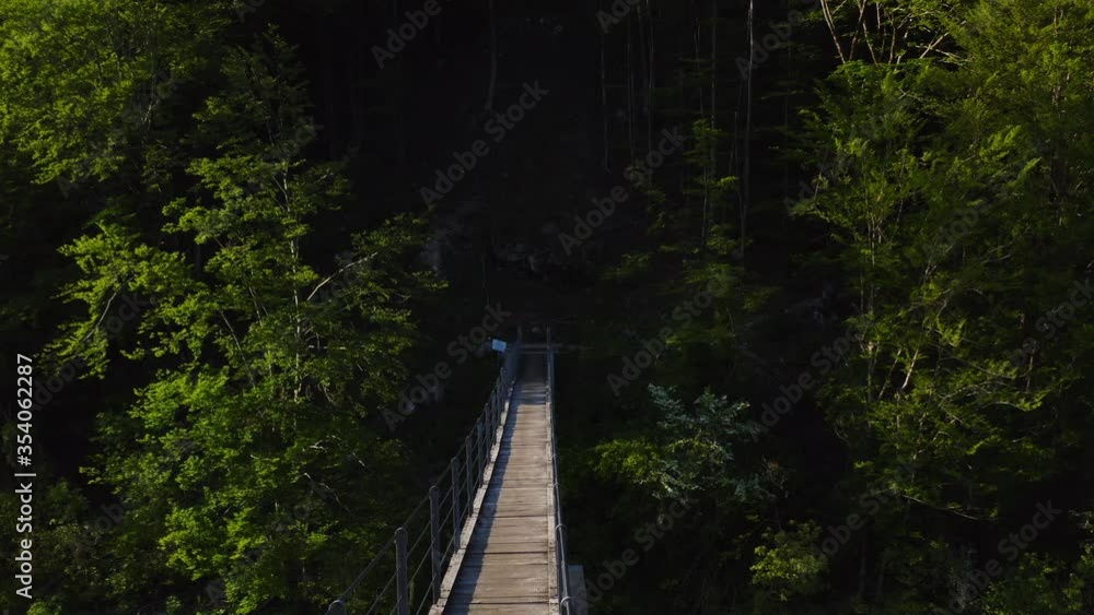 Gimbal moving forward shot of a hanging bridge over the river on a sunset Gimbal moving forward shot of a hanging bridge over the river on a sunset