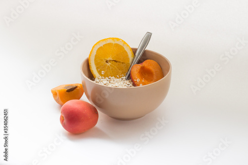 bowl with flakes and apricot on a white background