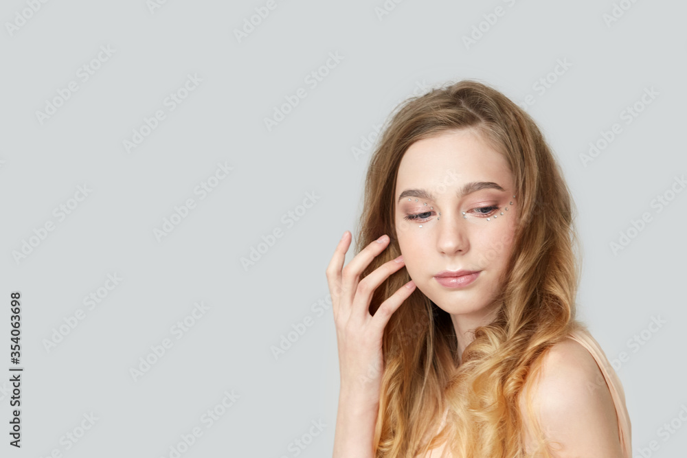 A girl with long blond hair on a gray background. A girl with long blond hair on a gray background.
