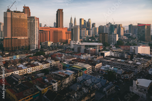 The center of Kuala Lumpur. On the horizon is a recognizable skyline of the city, visible Petronas towers. There is a contrast between the old low buildings and the modern city.