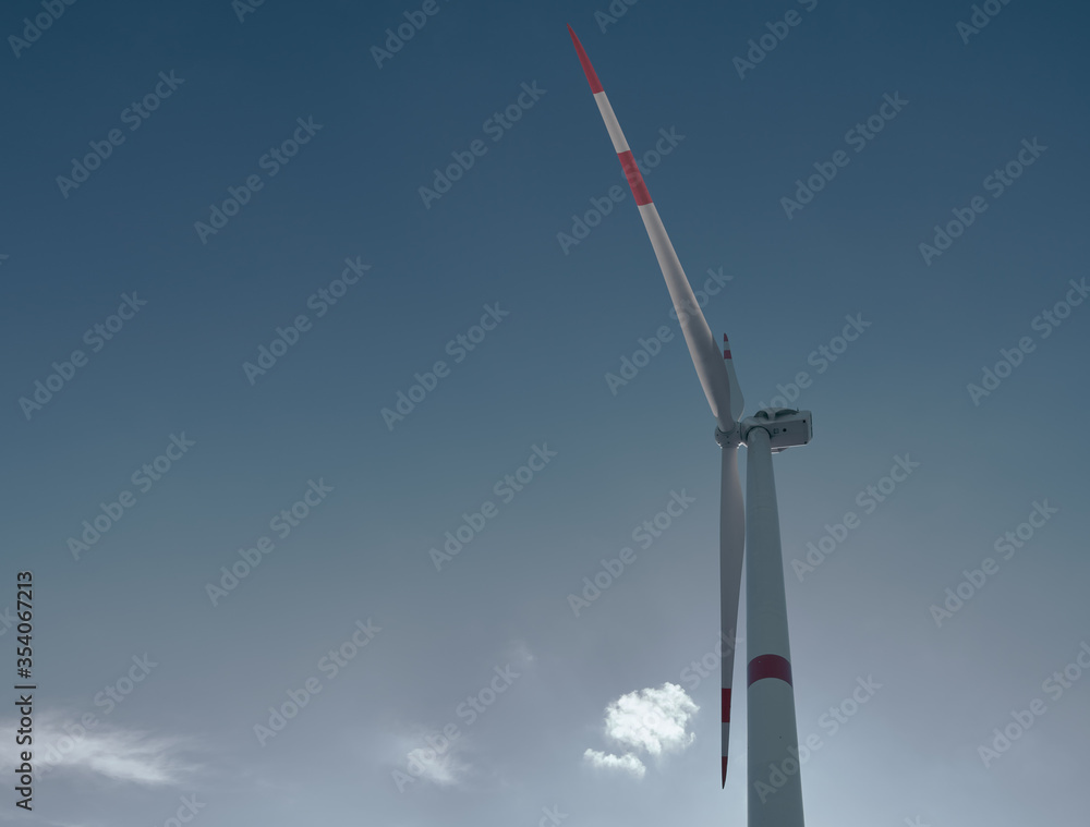 wind turbine on blue sky background with sun flare wind turbine on blue sky background with sun flare