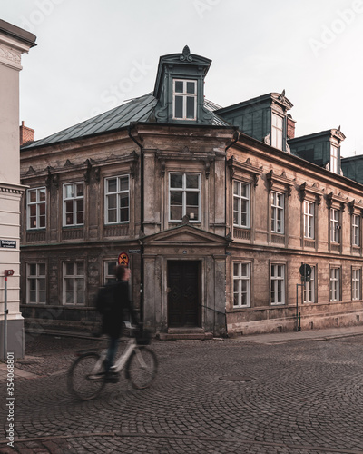 A university student is stressed and cycles by really fast on the cobblestoned streets of the old parts of Lund, Sweden