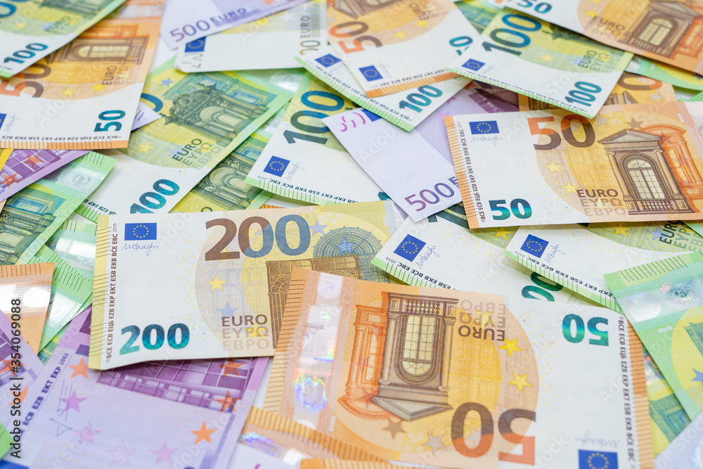 European currency lies on the table. Banknotes one hundred, two hundred, fifty, five hundred euros are scattered in a chaotic manner. Blank for design, background. Side view. European currency lies on the table. Banknotes one hundred, two hundred, fifty, five hundred euros are scattered in a chaotic manner. Blank for design, background. Side view.