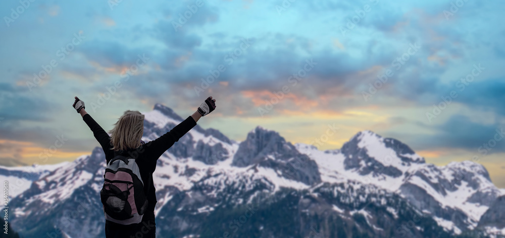 a traveler girl on mountain summit hands raised over clouds. a traveler girl on mountain summit hands raised over clouds.