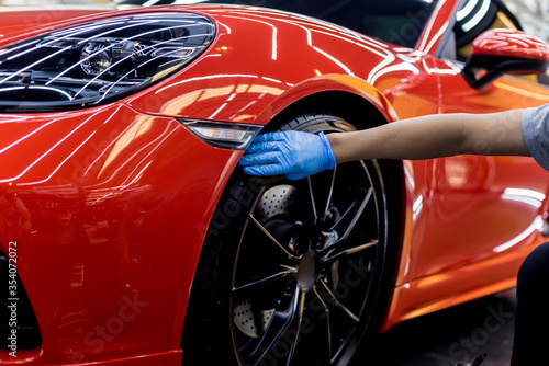 Car service worker polishing car wheels with microfiber cloth. © romaset