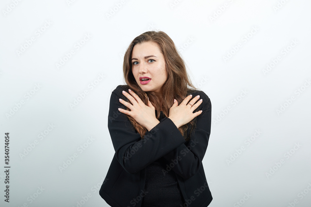 Young Attractive Woman Brunette In In Black T-Shirt, Sweater On White Background, A Terrified Female Crossed Fingers On Her Chest. The Concept Of People's Fear And Surprise Young Attractive Woman Brunette In In Black T-Shirt, Sweater On White Background, A Terrified Female Crossed Fingers On Her Chest. The Concept Of People's Fear And Surprise