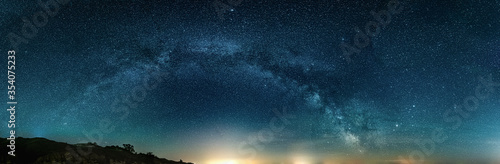 Scenic vivid panoramic landscape view of milky way over night sky photo