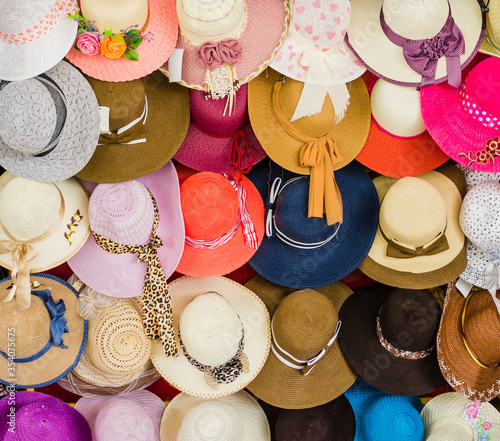 Display of pretty straw hats for ladies, with flower pattern, multi-colored bows and chiffon ribbons decoration