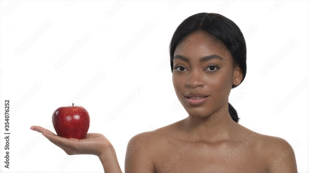 Young fitness African woman is holding red juicy apple. Healthy lifestyle concept Young fitness African woman is holding red juicy apple. Healthy lifestyle concept