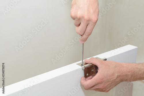 Installing the door hinge on a white door leaf