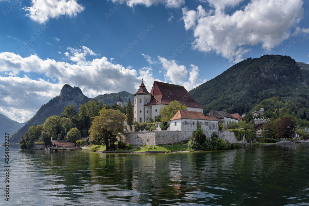 Iconic view from Lake Traunsee to parish church and former monastery of Traunkirchen, alpine mountains in background, Salzkammergut, Upper Austria, Europe