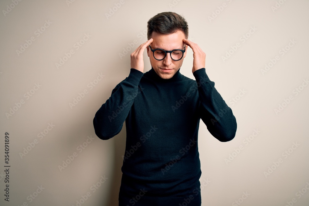 Young handsome caucasian man wearing glasses and casual sweater over isolated background with hand on head for pain in head because stress. Suffering migraine. Young handsome caucasian man wearing glasses and casual sweater over isolated background with hand on head for pain in head because stress. Suffering migraine.