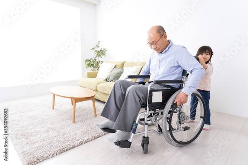 車椅子に乗る高齢男性と女の子