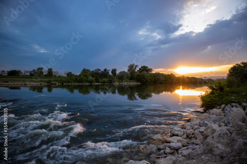 Beautiful sunset over Sava river rapids on the outskirts of Zagreb city, before the approaching rain
