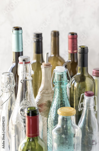 A close up of several different types and sizes of bottles against a bright background. photo